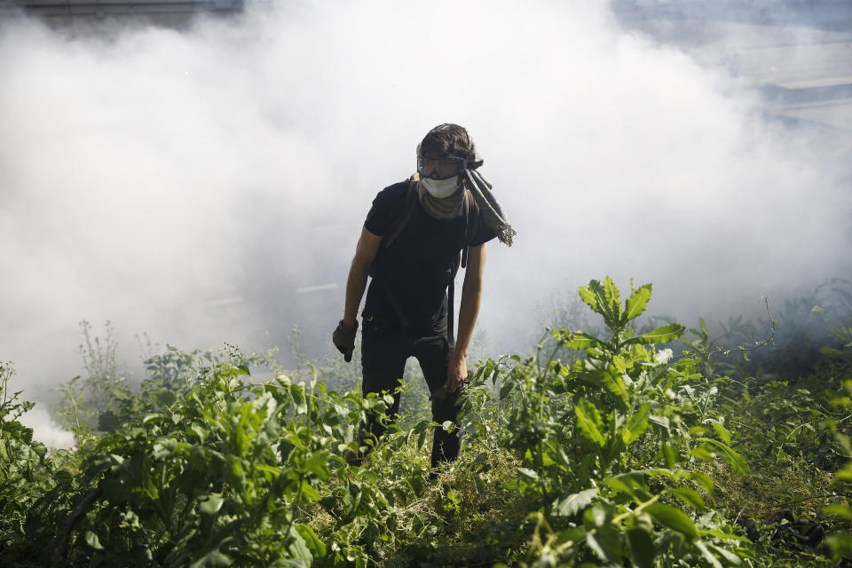 FILE—In this file photo from June 1, 2020, a protester walks in Philadelphia near smoke after tear gas was dispersed during a march calling for justice over the death of George Floyd who died after being restrained by Minneapolis police officers on May 25. Philadelphia's mayor and police chief are scheduled to give an update Thursday, June 25, 2020, on the investigation into the police use of tear gas and rubber bullets on demonstrators who had made it onto Interstate 676 in the early June protest. (AP Photo/Matt Rourke, File)