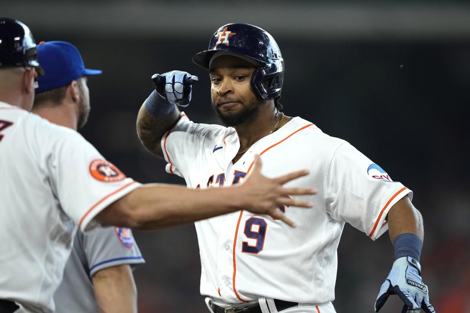 Houston Astros' Corey Julks (9) celebrates with first base coach Omar López, left, after hitting a two-run single against the New York Mets during the third inning of a baseball game Wednesday, June 21, 2023, in Houston. (AP Photo/David J. Phillip)