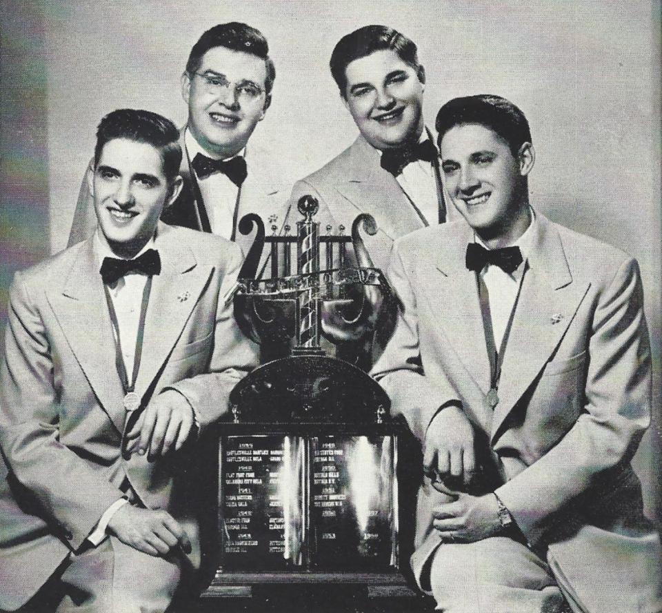 The Schmitt Brothers quartet posed with the SPEBSQSA trophy following their victory in 1951. 
(Back: Fran and Joe. Front: Jim and Paul.)