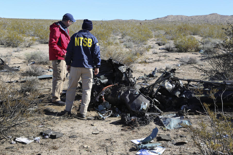 FILE - NTSB investigators survey the site of an Airbus Helicopters EC-130 on Sunday, Feb. 11, 2024, near Halloran Springs, Calif. The crash in the Mojave Desert killed, Herbert Wigwe, CEO of one of Nigeria's largest banks along with his wife and son. Investigators with the National Transportation Safety Board say, Friday, Feb. 23, 2024, the helicopter left a shallow crater when it crashed earlier this month in Southern California’s Mojave Desert. (Peter Knudson/NTSB via AP)