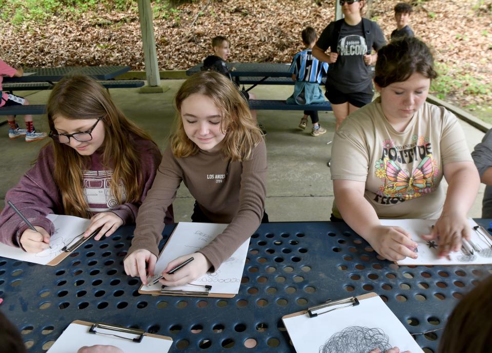 Fairless Elementary School fifth graders Annabelle Edmunds, 10, Audrey Staats, 11, and Miranda Fogle, 11, work on sketches during an outing at the Navarre-Bethlehem Township Park.