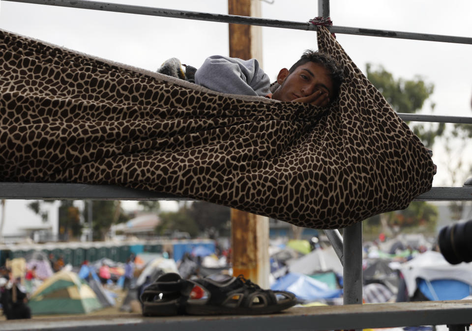 A migrant rests inside a blanket cocoon tied to keep him from rolling off the spectator stands while sleeping, at a sports complex where more than 5,000 Central American migrants are sheltering in Tijuana, Mexico, Wednesday, Nov. 28, 2018. As Mexico wrestles with what to do with the thousands of people camped out in the border city of Tijuana, President-elect Andres Manuel Lopez Obrador's government signaled that it would be willing to house the migrants on Mexican soil while they apply for asylum in the United States, a key demand of U.S. President Donald Trump. (AP Photo/Rebecca Blackwell)