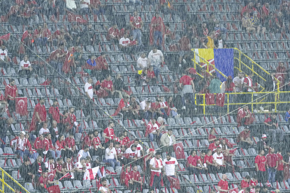 Heavy rain falls as Turkish fans sit in the stands ahead of a Group F match between Turkey and Georgia at the Euro 2024 soccer tournament in Dortmund, Germany, Tuesday, June 18, 2024. (AP Photo/Andreea Alexandru)