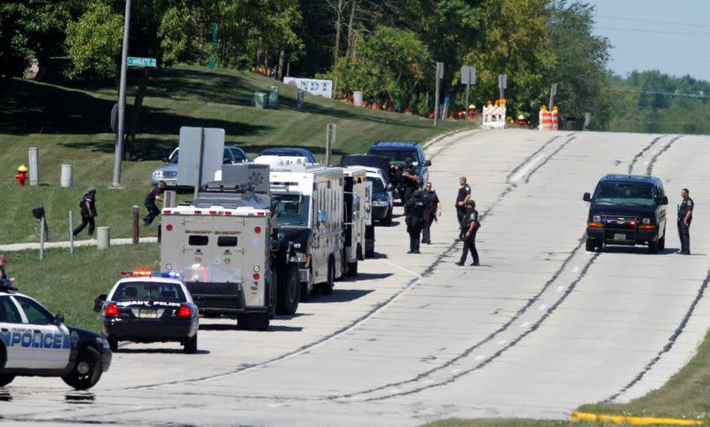 FILE PHOTO: Police walk around police tactical vehicles near the Sikh temple in Oak Creek, Wisconsin