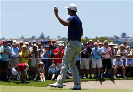 Australia's Adam Scott responds to the crowd after sinking a birdie putt on the 9th hole, his final hole for the round, during the first round of the Australian Open golf tournament at Royal Sydney Golf Club November 28, 2013. U.S. Masters champion Scott confirmed his remarkable form by carding a course record 10-under-par 62 in the first round of the Australian Open on Thursday. REUTERS/David Gray