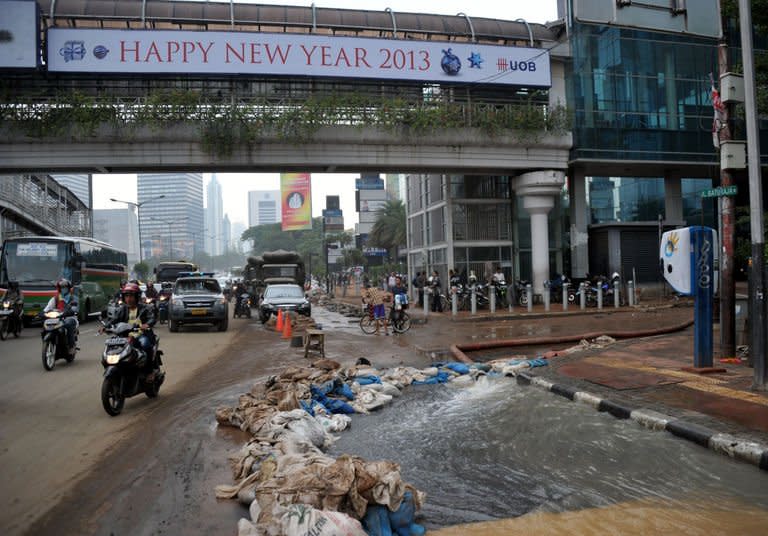 Hydro pumps remove water after flooding inside a building's parking lot in downtown Jakarta, on January 19, 2013, after three bodies were pulled out of the floodwaters. The death toll from floods in Indonesia's capital has so far risen to 15