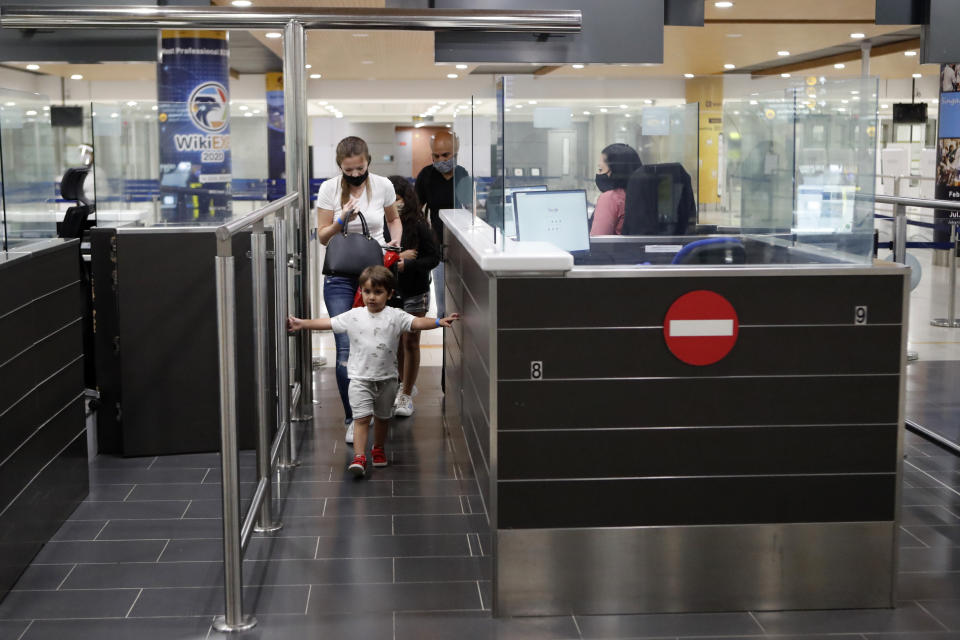 Family passengers from Israel wearing face masks walk through passport control after arriving at Cyprus' main airport in Larnaca, on Tuesday, June 9, 2020. Cyprus re-opened its airports on Tuesday to a limited number of countries after nearly three months of commercial air traffic as a result of a strict lockdown aimed at staving off the spread of COVID-19. (AP Photo/Petros Karadjias)