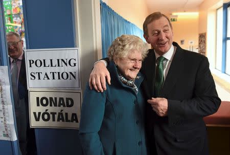 Irish Prime Minister Enda Kenny stands with 88-year-old Bridie McLoughlin in a polling station at St Anthony's School in Castlebar, Ireland February 26, 2016. REUTERS/Clodagh Kilcoyne