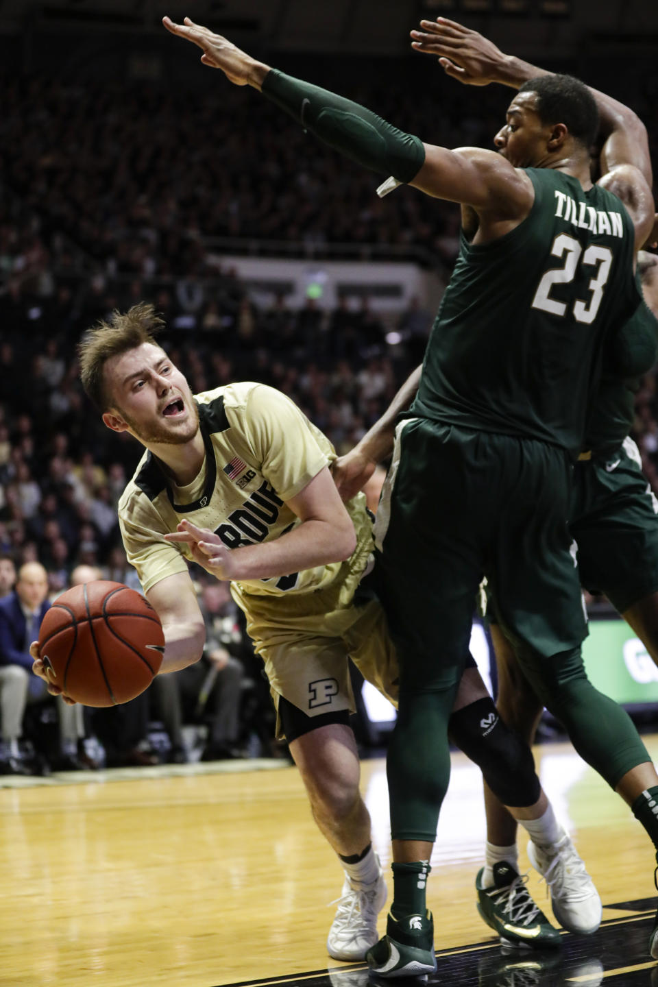 Purdue guard Sasha Stefanovic, left, passes around Michigan State forward Xavier Tillman (23) during the second half of an NCAA college basketball game in West Lafayette, Ind., Sunday, Jan. 12, 2020. (AP Photo/Michael Conroy)