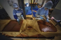 Workers of Yagisawa Shoten Co., prepare for soy sauce extractor of the company's factory in Ichinoseki, Iwate Prefecture, northeastern Japan Friday, March 5, 2021. Just a month after a tsunami smashed into the city of Rikuzentakata, soy sauce maker Michihiro Kono inherited his family's two-century-old business from his father. Later this year the ninth generation owner of Yagisawa Shoten Co. will open a new factory on the same ground where his family started making soy sauce in 1807. (AP Photo/Eugene Hoshiko)