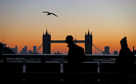 Dawn breaks and silhouettes Tower Bridge and commuters crossing the River Thames in London, Britain, December 13, 2018. REUTERS/Henry Nicholls