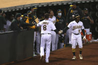 Oakland Athletics' Jed Lowrie is congratulated by teammates after scoring on a single by Seth Brown against the Tampa Bay Rays during the seventh inning of a baseball game in Oakland, Calif., Friday, May 7, 2021. (AP Photo/Jed Jacobsohn)