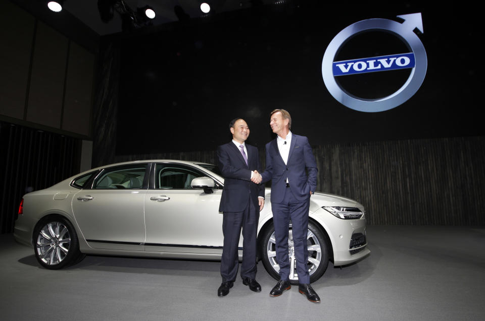 Li Shufu, Chairman of Zhejiang Geely Holdings, left, shakes hands with Hakan Samuelsson, CEO of Volvo Cars, right, in front of a new S90 Volvo car in Shanghai, China, Wednesday, Nov. 2, 2016. Volvo Cars and its Chinese owner are revving up their profile as they focus on selling premium cars in world markets. The companies announced a strategy Wednesday that includes a new factory to make vehicles based on a new shared platform, including vehicles for Geely's new 