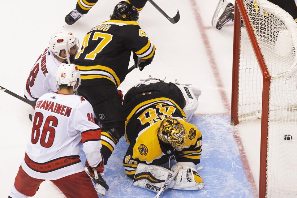 Boston Bruins goaltender Tuukka Rask (40) watches the puck cross the line on what would be ruled no goal due to goalie interference as Carolina Hurricanes' Teuvo Teravainen (86), Hurricanes' Jordan Martinook (48) and Bruins' Torey Krug (47) look on during third-period NHL hockey first-round Stanley Cup playoff action in Toronto, Thursday, Aug. 13, 2020. (Chris Young/The Canadian Press via AP)