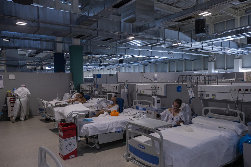 COVID-19 patients receive treatment at the new Nurse Isabel Zendal Hospital in Madrid Madrid, Spain, Monday, Jan. 18, 2021. As the coronavirus curve of contagion turned increasingly vertical after Christmas and New Year's, the Zendal has been busy. On Monday, 392 virus patients were being treated, more than in any other hospital in the Madrid region. (AP Photo/Bernat Armangue)