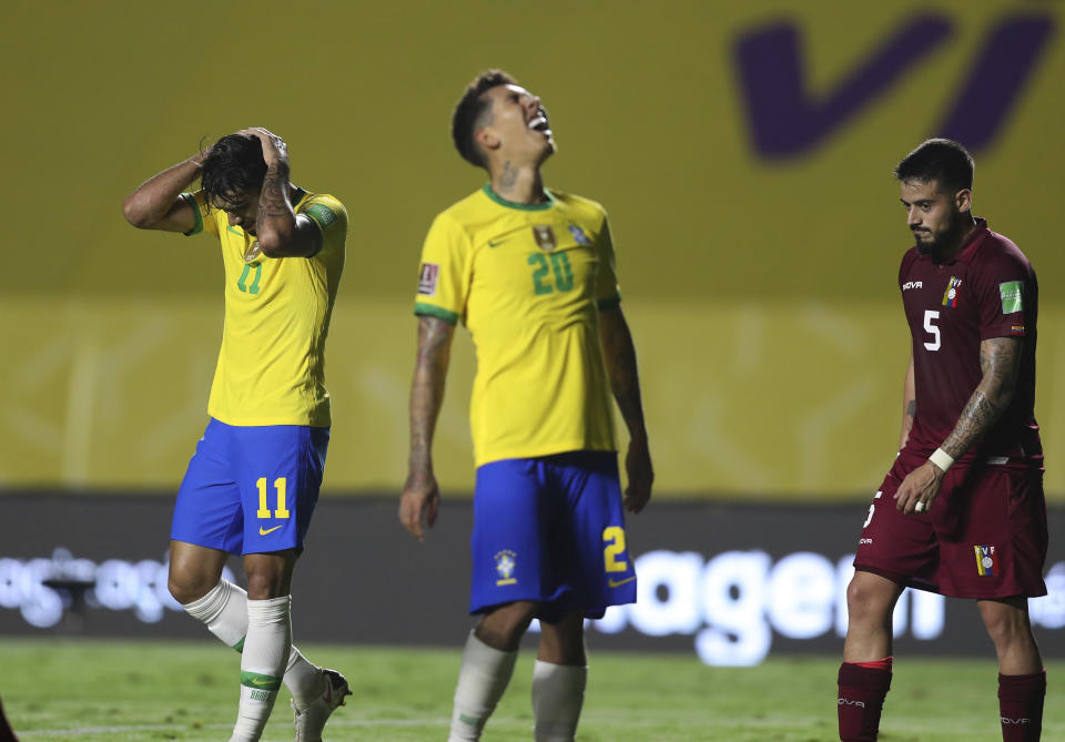 Brazil's Lucas Paqueta, left, and Brazil's Roberto Firmino, center, react during a qualifying soccer match against Venezuela for the FIFA World Cup Qatar 2022 in Sao Paulo, Brazil, Friday, Nov.13, 2020. (Fernando Bizerra/Pool via AP)