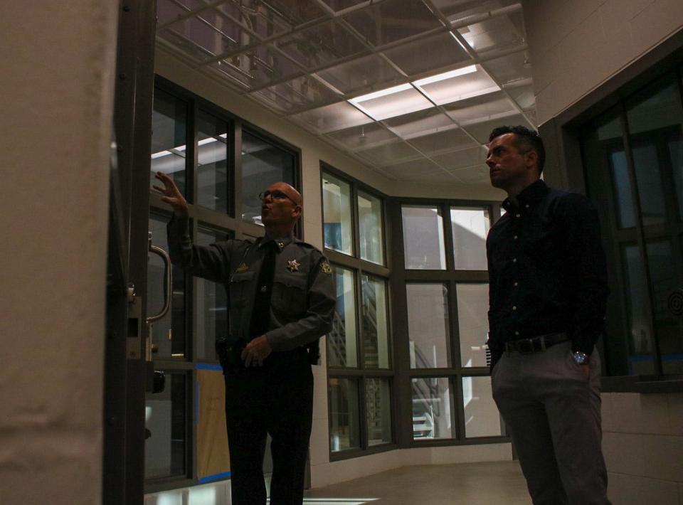 Saline County Sheriff's Office Operations Captain Jim Hughes, left, talks about the new jail cells on a tour of the jail Oct. 31.