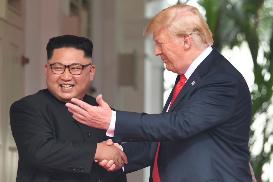 <p>President Donald Trump (R) shakes hands with North Korea’s leader Kim Jong Un as they meet at the start of their historic US-North Korea summit, at the Capella Hotel on Sentosa island in Singapore on June 12, 2018. (Photo: Saul Loeb/AFP/Getty Images) </p>