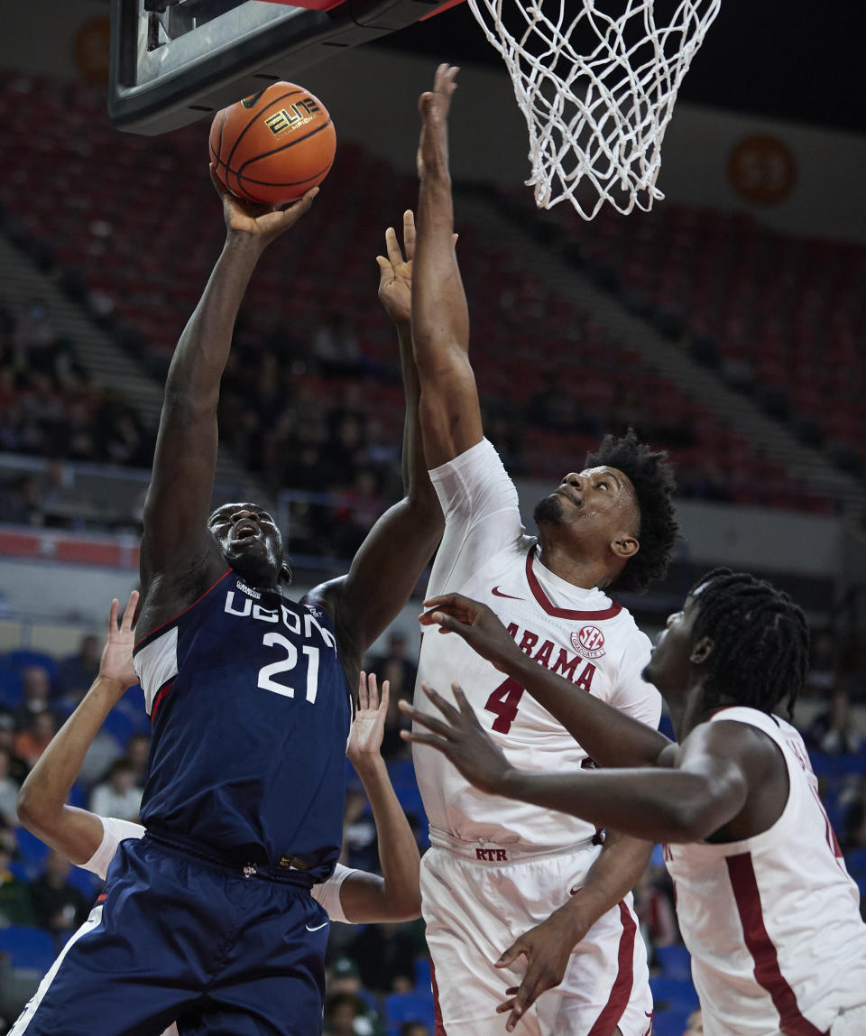 Connecticut forward Adama Sanogo, left, shoots next to Alabama forward Noah Gurley during the first half of an NCAA college basketball game in the Phil Knight Invitational tournament in Portland, Ore., Friday, Nov. 25, 2022. (AP Photo/Craig Mitchelldyer)