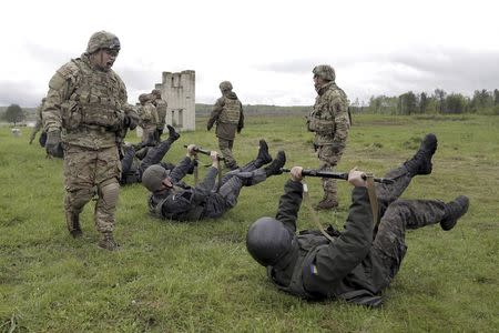 Servicemen of the U.S. Army's 173rd Airborne Brigade Combat Team (standing) train members of the Ukrainian National Guard during a joint military exercise called "Fearless Guardian 2015" at the International Peacekeeping and Security Center near the western village of Starychy, Ukraine, in this file picture taken May 7, 2015. REUTERS/Roman Baluk/Files