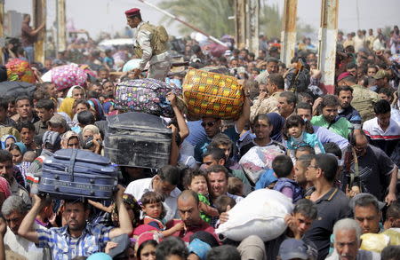 Displaced Sunni people, who fled the violence in the city of Ramadi, arrive at the outskirts of Baghdad, April 17, 2015. REUTERS/Stringer