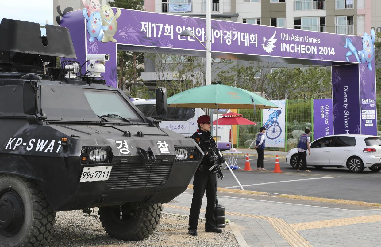 An armed SWAT officer stands guard outside the athletes village for the 17th Asian Games in Incheon, South Korea, Thursday, Sept. 18, 2014. The South Korean west city will host the 17th Asian Games which will be held from Sept. 19 to Oct. 4.(AP Photo/Rob Griffith)