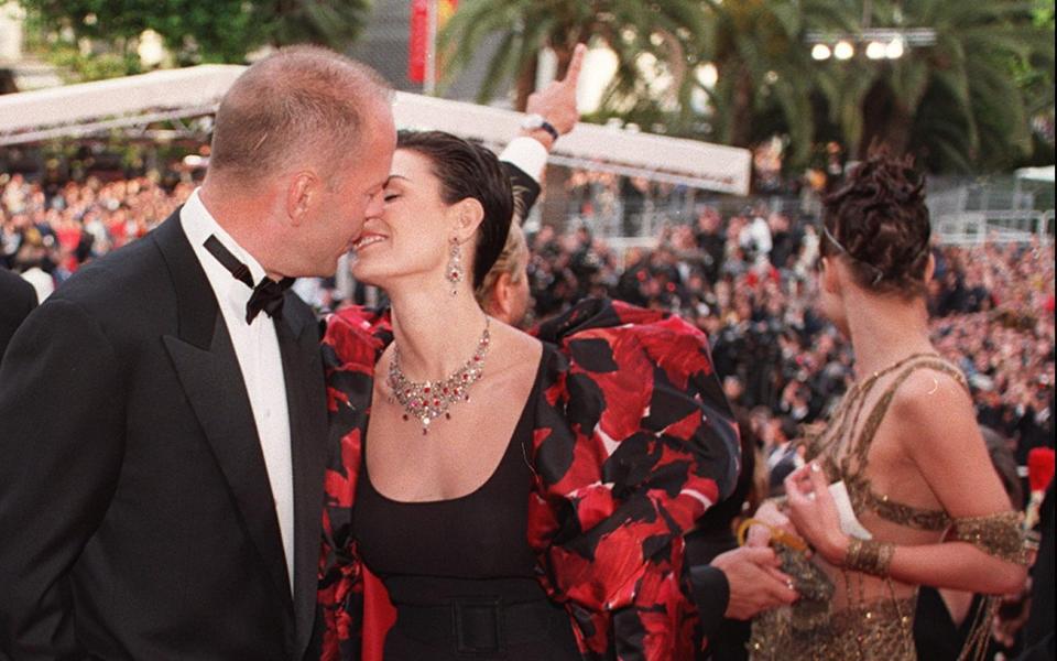 Bruce Willis and Demi Moore kiss at the top of the steps of the Palais des Festivals during the premiere of The Fifth Element