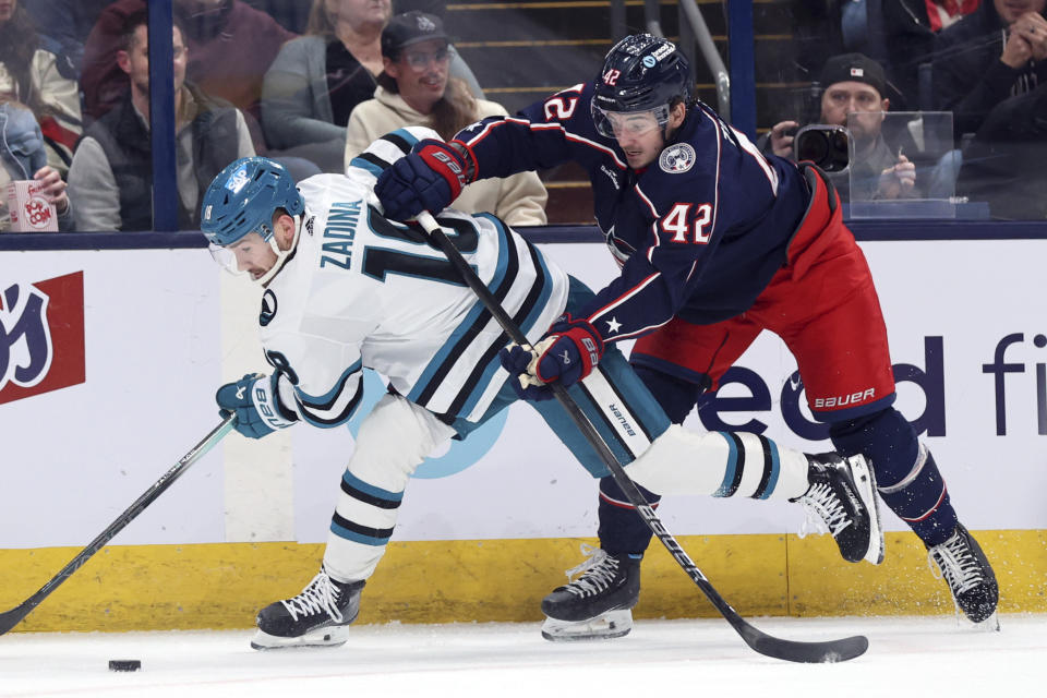 Columbus Blue Jackets forward Alexandre Texier (42) checks San Jose Sharks forward Klim Kostin during the first period of an NHL hockey game in Columbus, Ohio, Saturday, March 16, 2024. (AP Photo/Paul Vernon)