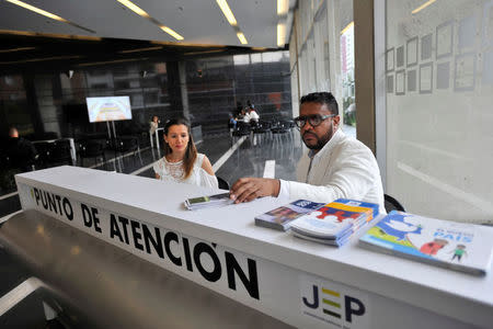 Officials of the Special Jurisdiction for Peace (JEP) tribunal, founded under a 2016 peace deal between the government and Revolutionary Armed Forces of Colombia (FARC) rebels, sit at an information booth, in Bogota, Colombia March 15, 2018. REUTERS/Carlos Julio Martinez NO RESALES. NO ARCHIVES.