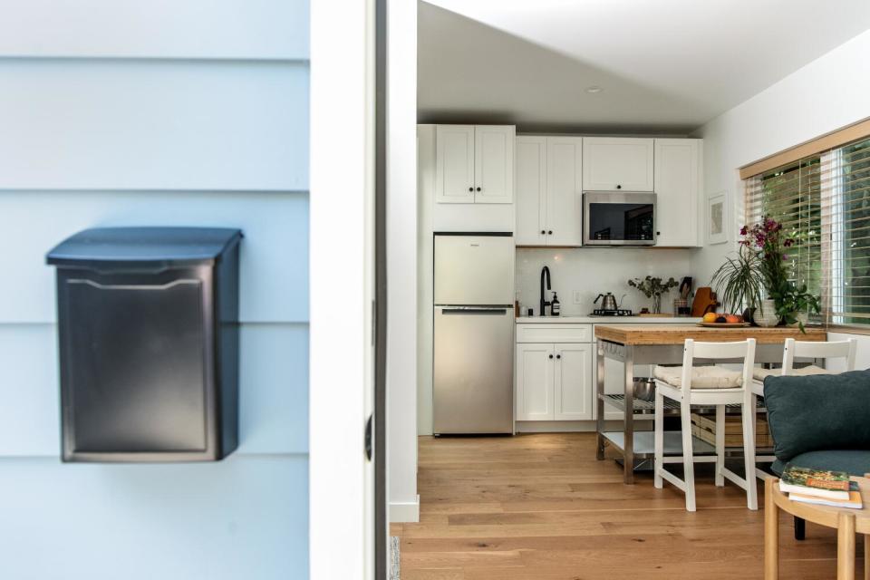 A mailbox hangs on the wall, left, next to a door opening to the kitchen of the ADU.