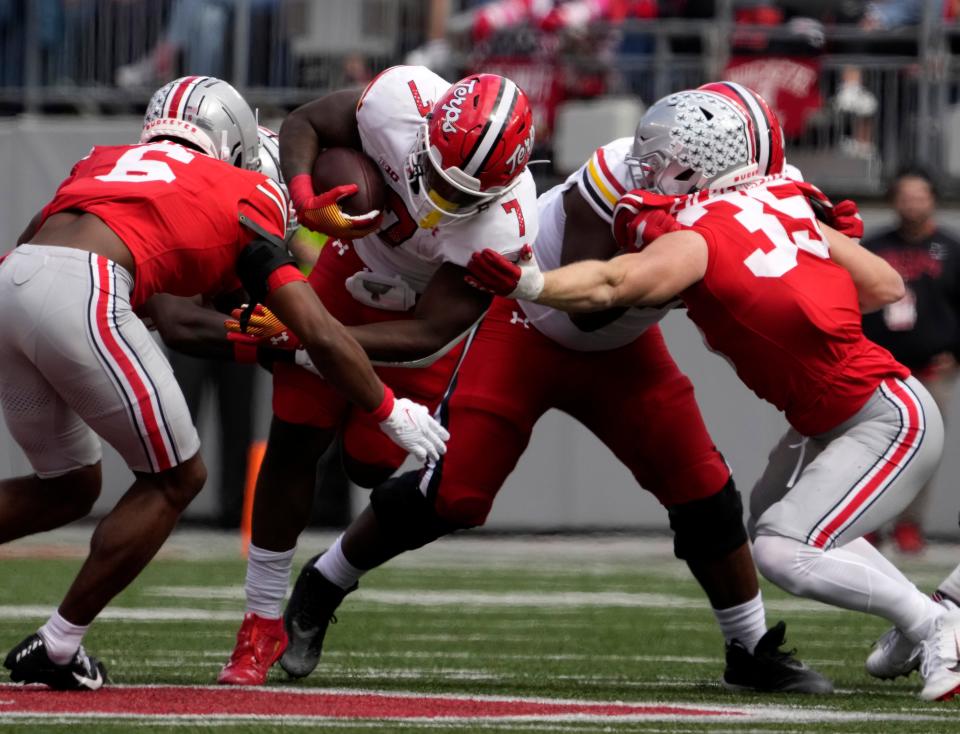 Maryland running back Antwain Littleton II is tackled by Ohio State's Sonny Styles (6) and Tommy Eichenberg on Saturday.