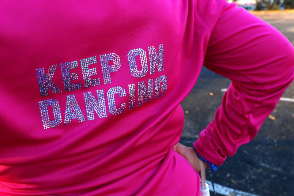 The words Keep On Dancing decorate on the back of Kathi Schmeling's jacket as she marches at a practice of the Milwaukee Dancing Grannies on Wednesday, Nov. 2, 2022, in Milwaukee. Schmeling, 62, ran from the street to avoid injury when the driver of an SUV sped through the route of a Christmas parade last November in Waukesha, Wisconsin.