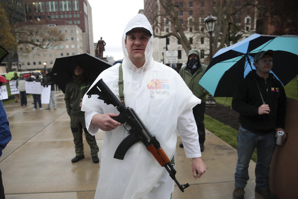 A protester carries his rifle during a rally against Michigan’s coronavirus stay-at-home order at the State Capitol in Lansing, Mich., Thursday, May 14, 2020. (AP Photo/Paul Sancya)