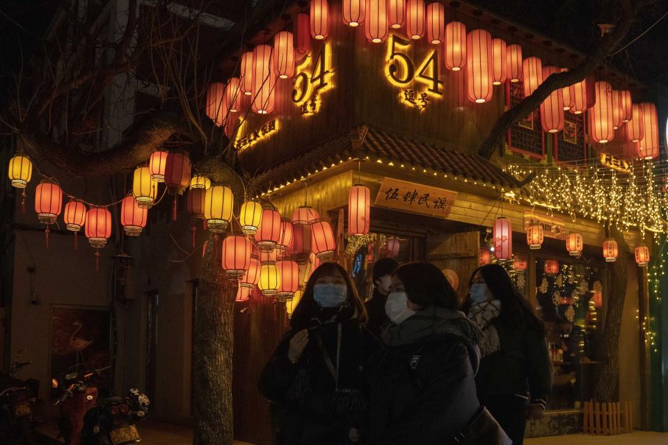 Patrons wearing masks to protect from the coronavirus visit a bar street on New Year Eve in Beijing on Thursday, Dec. 31, 2020. This New Year's Eve is being celebrated like no other, with pandemic restrictions limiting crowds and many people bidding farewell to a year they'd prefer to forget. (AP Photo/Ng Han Guan)