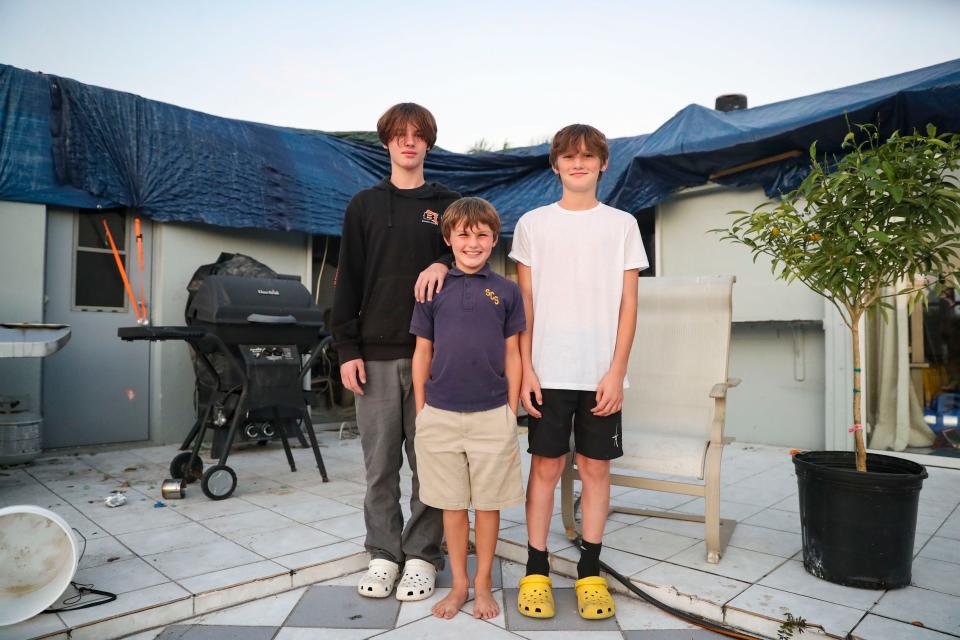 From left: Ryder, 14, Luke, 8, and Eli Collins, 12, pose at their home in Cape Coral on Monday, Dec. 12, 2022. Much of the home they moved into in June was damaged during Hurricane Ian.