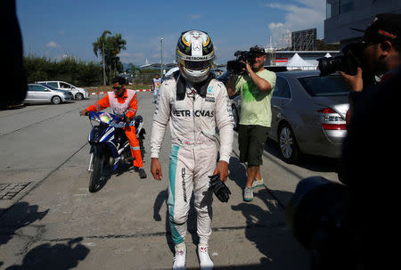 Formula One - F1 - Malaysia Grand Prix - Sepang, Malaysia- 2/10/16 Mercedes' Lewis Hamilton of Britain returns to the paddock after his car caught fire during the race. REUTERS/Edgar Su