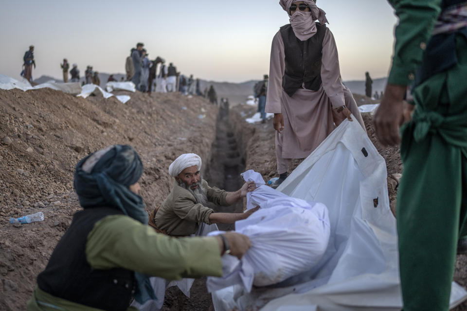 Afghans bury hundreds of people killed in an earthquake at a burial site, outside a village in Zenda Jan district in Herat province, western of Afghanistan, Monday, Oct. 9, 2023. Saturday's deadly earthquake killed and injured thousands when it leveled an untold number of homes in Herat province. (AP Photo/Ebrahim Noroozi)