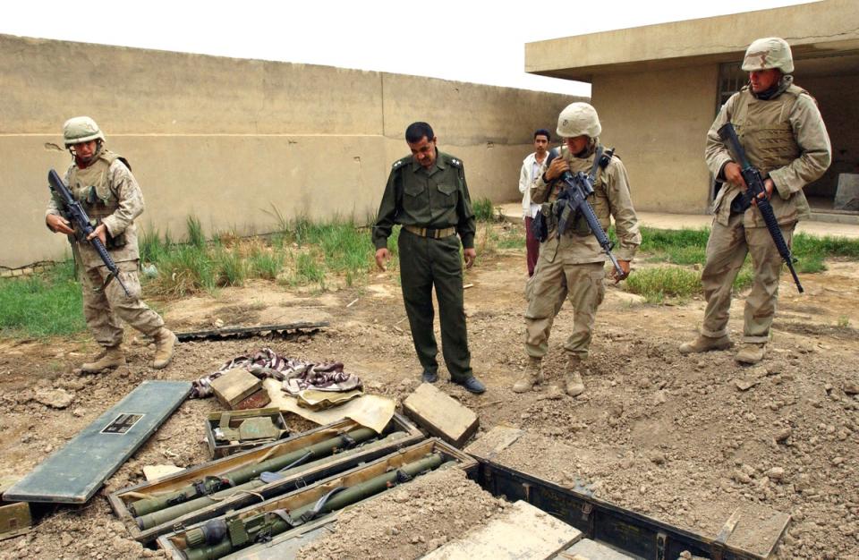 US marines on patrol with Iraqi police officers discover dozens of boxes of Russian made missile launchers hidden in the garden of a school in Baghdad on 16 April, 2003 (Getty)