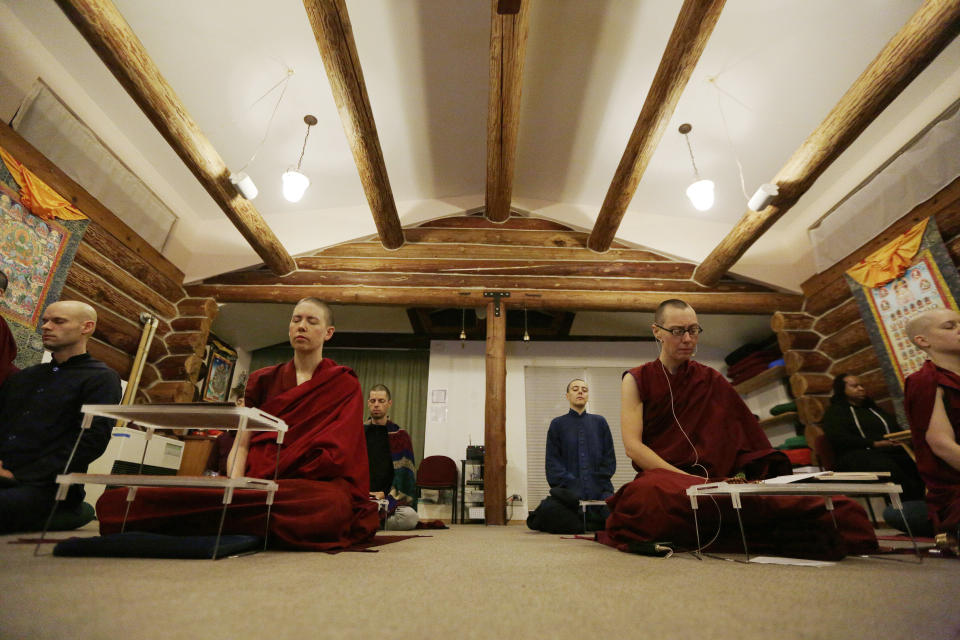 Thubten Rinchen, left, Thubten Dekyi, both ordained Buddhist nuns, along with other residents and guests sit in mediation at Sravasti Abbey, Thursday, Nov. 18, 2021, in Newport, Wash. (AP Photo/Young Kwak)