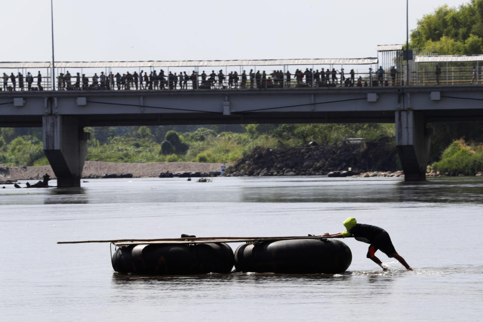 <p>A man pushes a raft across the Suchiate river as Central American migrants wait in line to cross the bridge over the border between Guatemala and Mexico, near Ciudad Hidalgo, Chiapas State, Mexico, Thursday, Jan. 17, 2019. Hundreds of Central American migrants are walking and hitchhiking through the region as part of a new caravan of migrants hoping to reach the United States. (AP Photo/Marco Ugarte) </p>