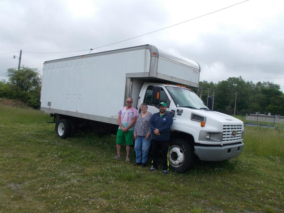 From left, volunteers Mike Williams, Bev Albright and Clyde Officer Dana Widman stand in front of the new truck purchased by the Back Door Food Pantry.