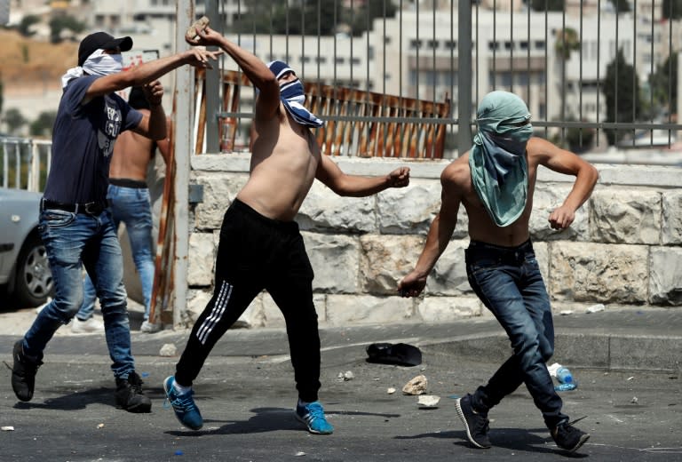 Palestinians hurl stones at Israeli forces after they used stun grenades and tear gas to disperse Muslim worshippers following protest prayers held outside Jerusalem's Old City on July 21, 2017