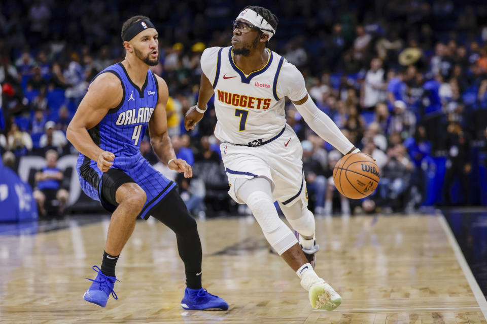 Denver Nuggets guard Reggie Jackson (7) drives against Orlando Magic guard Jalen Suggs (4) during the first half of an NBA basketball game, Wednesday, Nov. 22, 2023, in Orlando, Fla. (AP Photo/Kevin Kolczynski)