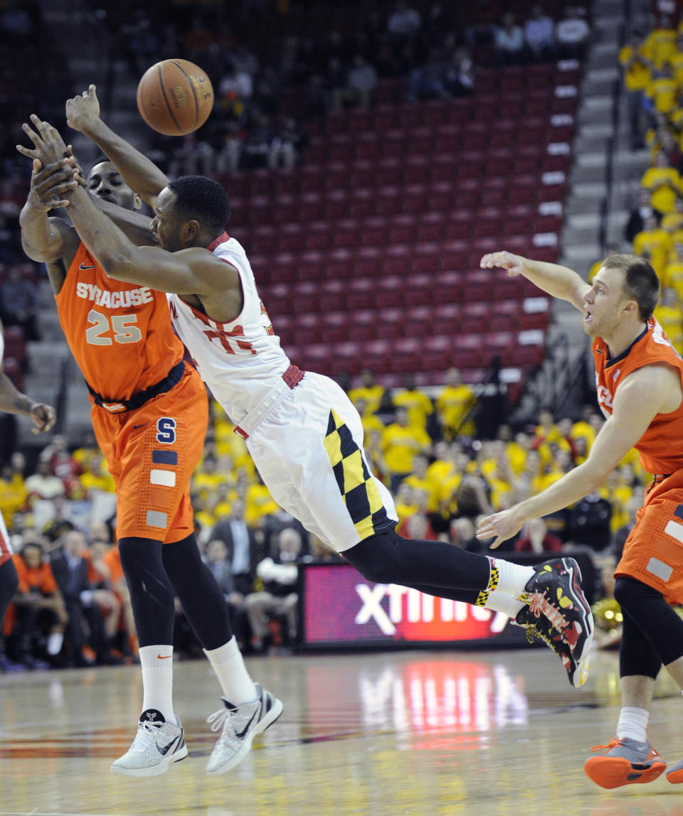 Maryland's Dez Wells, center, battles for the ball against Syracuse forward Rakeem Christmas (25) and Trevor Cooney, right, during the first half of an NCAA college basketball game, Monday, Feb. 24, 2014, in College Park, Md. (AP Photo/Nick Wass)