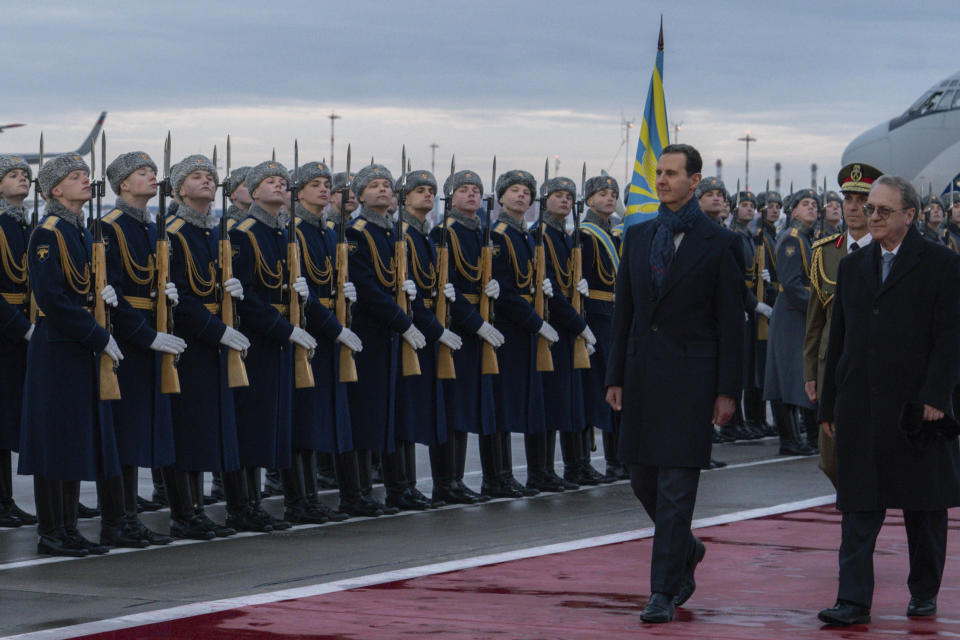 In this photo released by the Syrian official news agency SANA, visiting Syrian President Bashar Assad, left, and Mikhail Bogdanov, left, Deputy Minister of Foreign Affairs of Russia and Special Representative of the President of Russia for the Middle East review an honor guard during a welcome ceremony upon A'ssads arrival at Vnukovo airport in Moscow, Russia, Tuesday, March 14, 2023. Assad Tuesday landed in Russia where he is scheduled to meet top ally President Vladimir Putin. (SANA via AP)