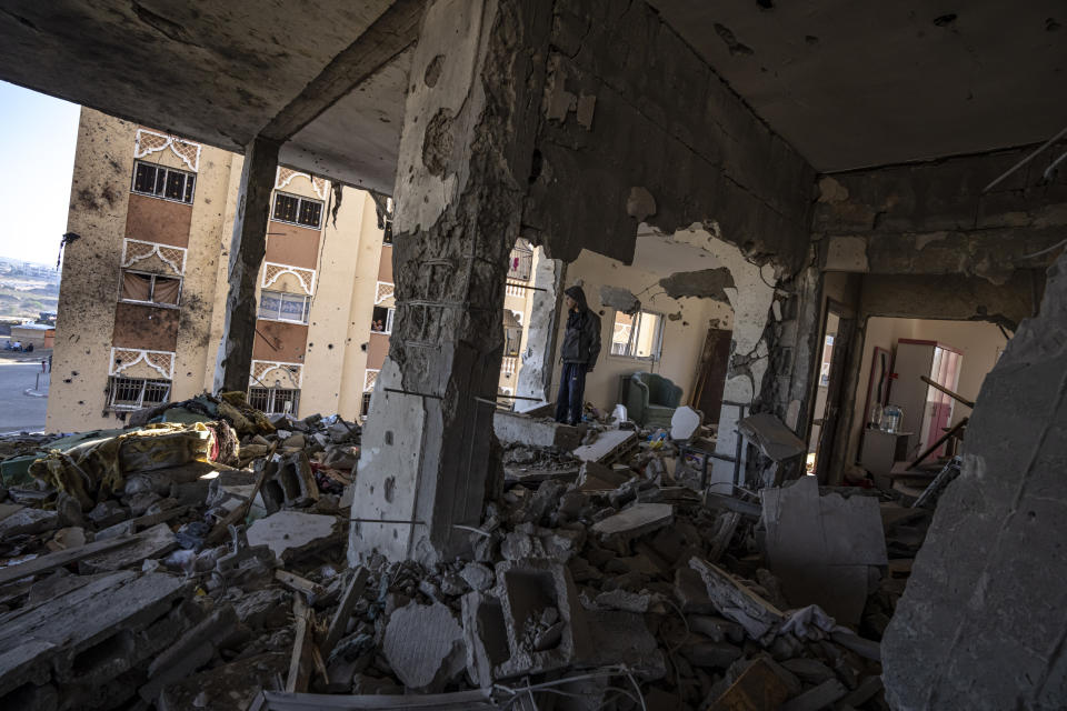 Palestinians look at destruction after an Israeli strike on the Gaza Strip in Khan Younis, Saturday, Nov. 18, 2023. (AP Photo/Fatima Shbair)