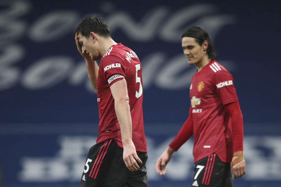 Harry Maguire (izquierda) y Edinson Cavani del Manchester United reaccionan durante el partido contra West Brom en la Liga Premier inglesa, el domingo 14 de febrero de 2021 en West Bromwich. (Nick Potts/Pool Foto vía AP)