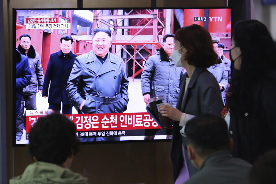 People watch a TV showing a file image of North Korean leader Kim Jong Un during a news program at the Seoul Railway Station in Seoul, South Korea, Saturday, May 2, 2020. Kim made his first public appearance in several weeks as he celebrated the completion of a fertilizer factory near Pyongyang, state media said Saturday, ending an absence that had triggered global rumors that he was seriously ill. The sign reads: "Kim Jong Un attended a ceremony marking the completion of a fertilizer factory." (AP Photo/Ahn Young-joon)