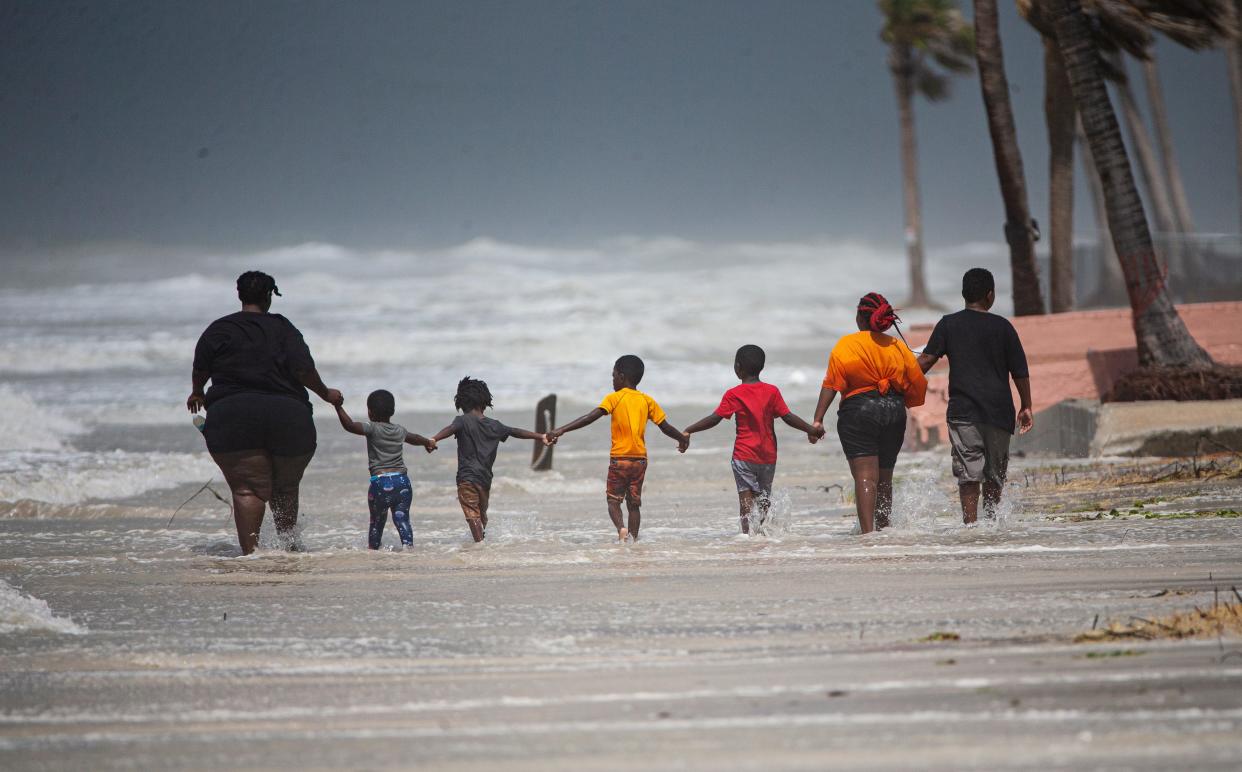 Members of the Jackson and Cledanor family take in the remnants of Hurricane Idalia as it churns north at Fort Myers Beach on Wednesday, Aug. 30 2023. Hurricane Idalia passed by the area the night before.