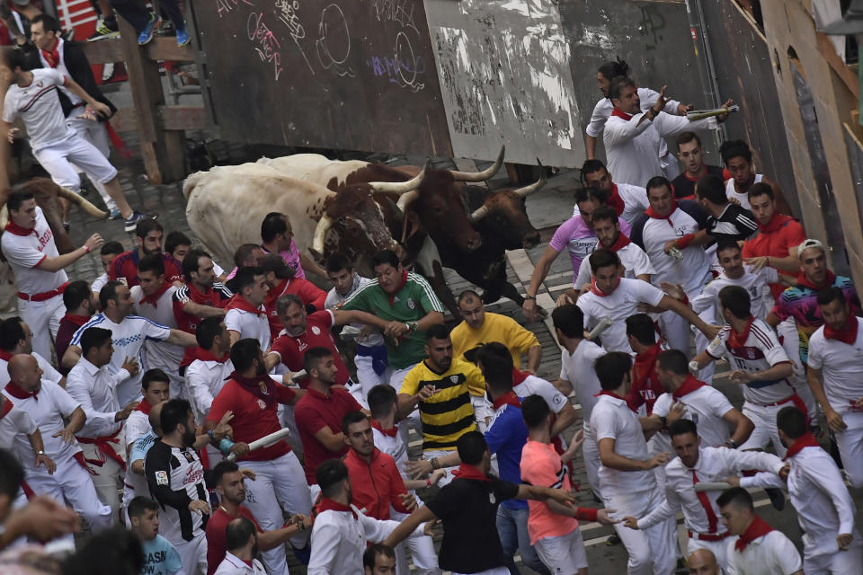 <p>Revellers run next to a fighting bull from the Cebada Gago ranch accompanied by steers during the third day of the running of the bulls at the San Fermin Festival in Pamplona, northern Spain, July 9, 2018. (Photo: Alvaro Barrientos/AP) </p>